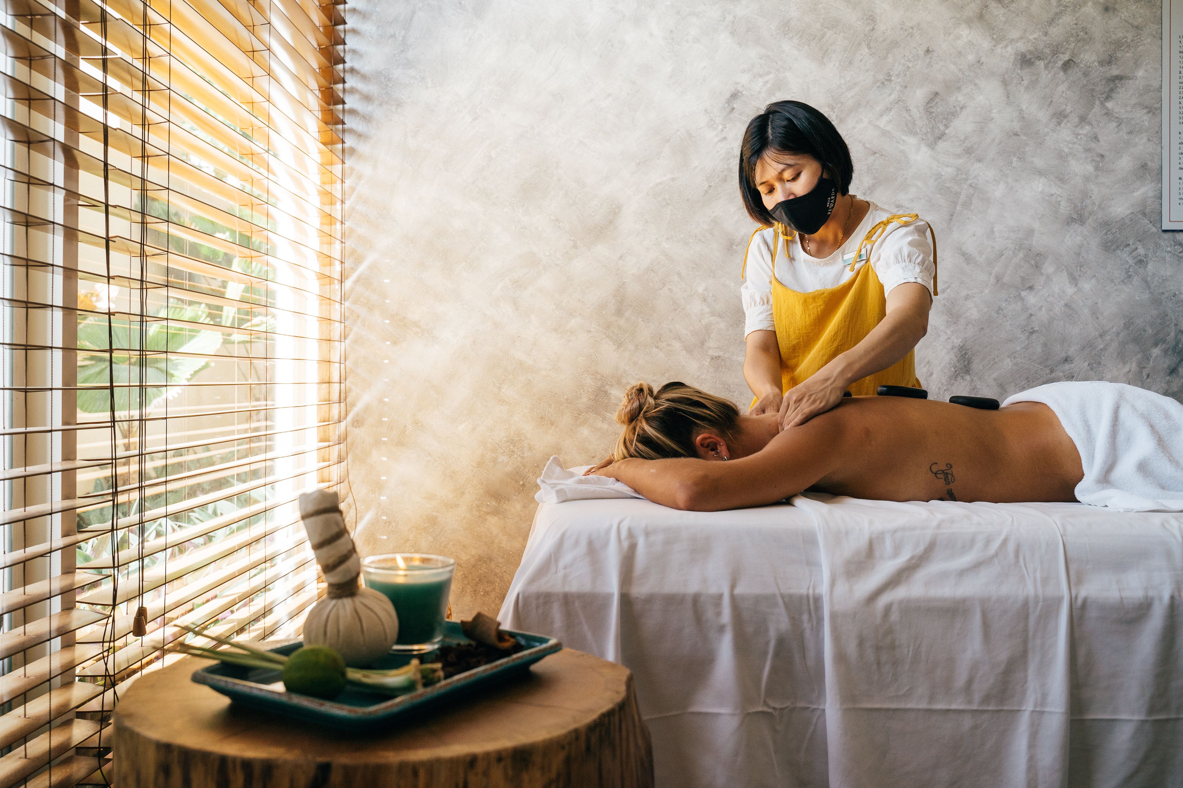 Scented oil being warmed between the hands before a massage