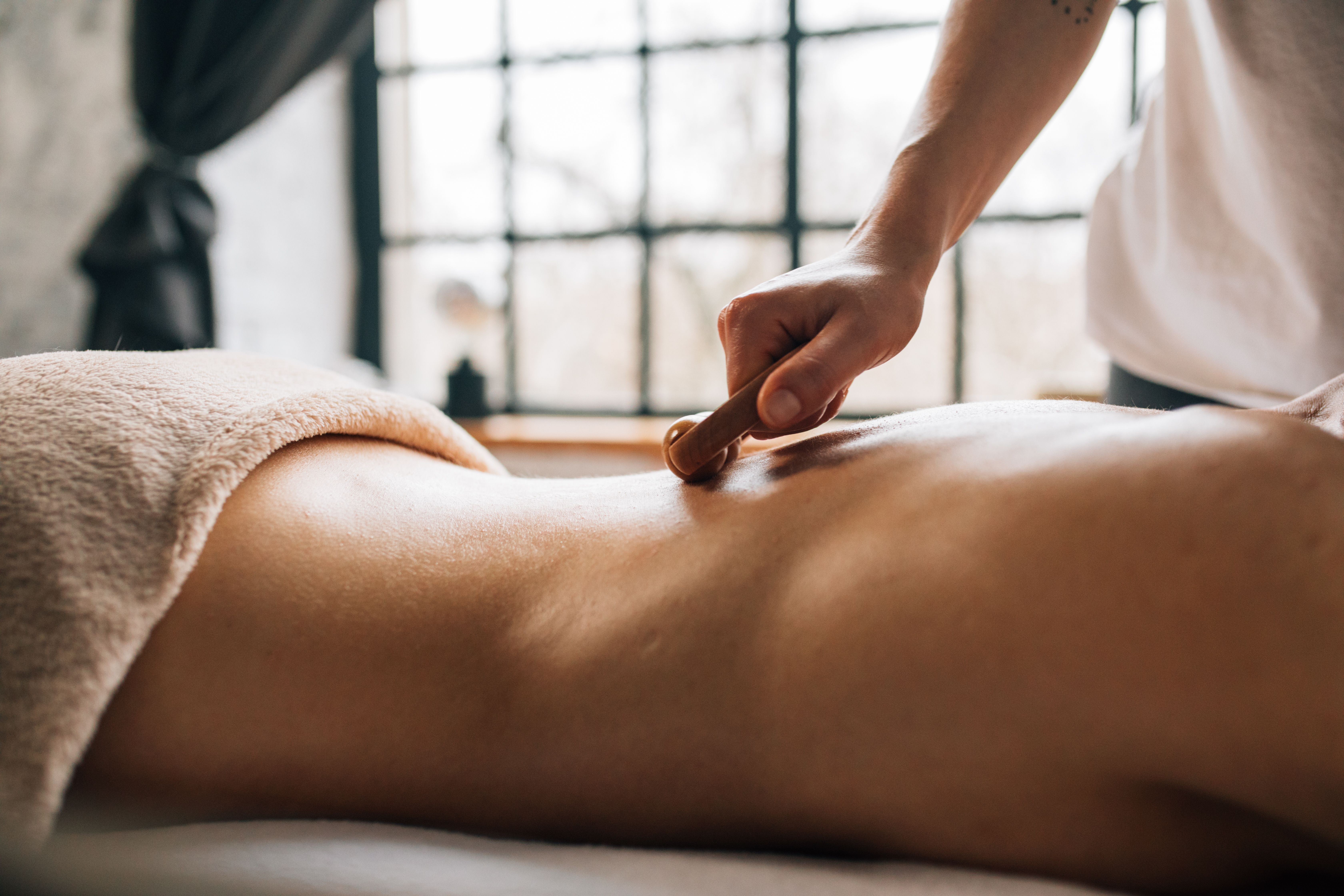 Therapist pressing an acupressure point at the base of the neck during a Chinese massage