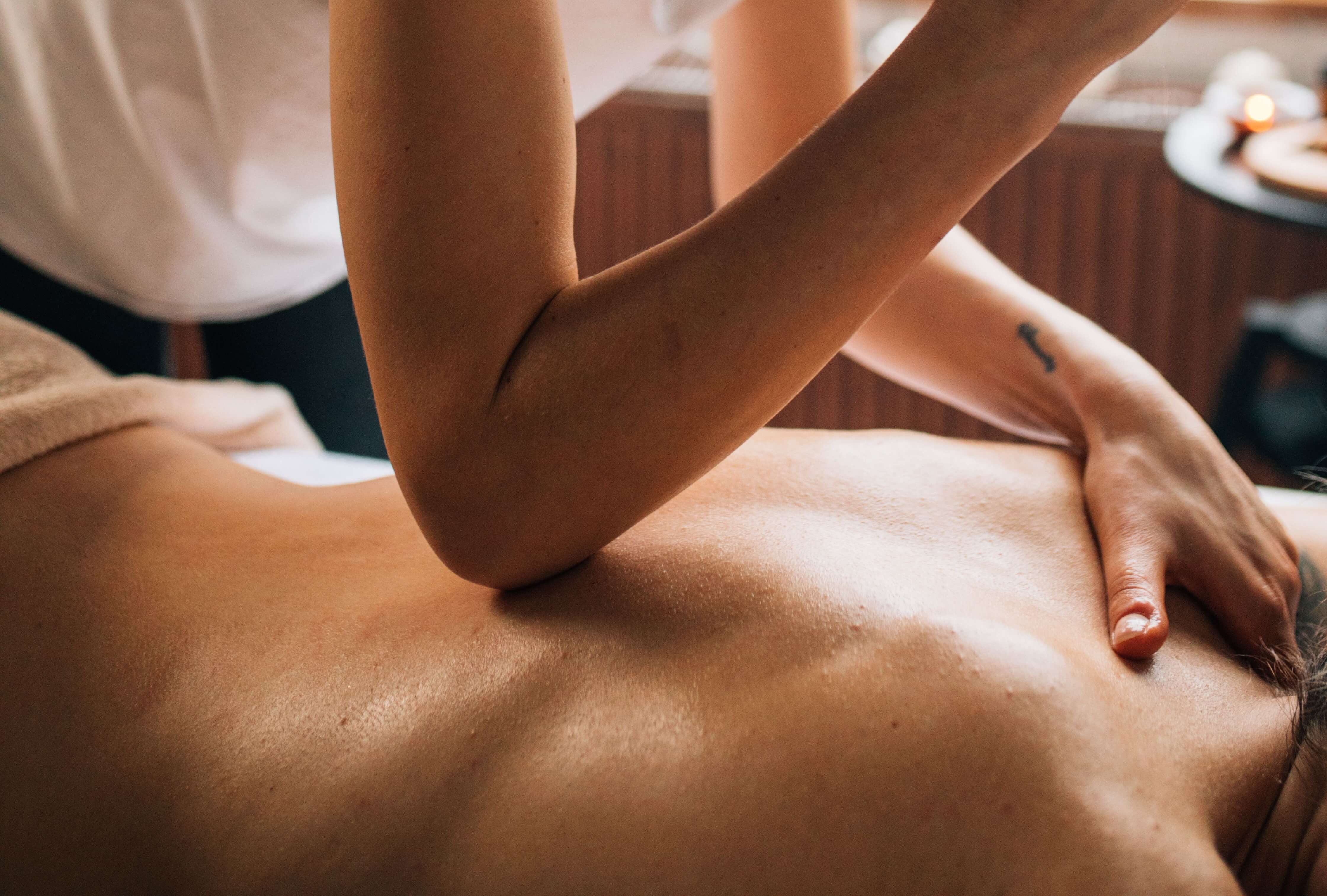 Thumbs working into a knot beside the shoulder blade