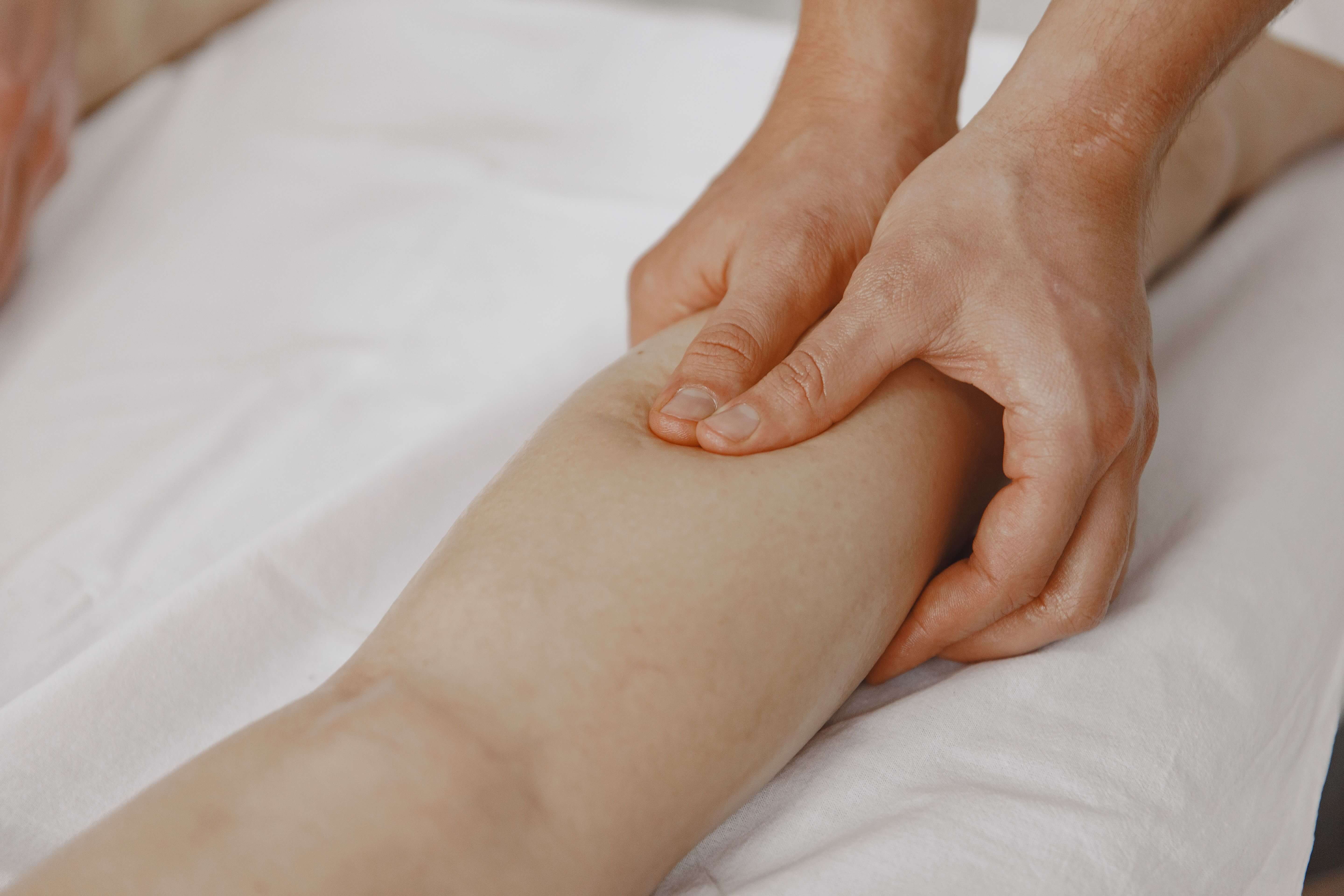 Hands resting lightly on a client's shoulder during a gentle massage