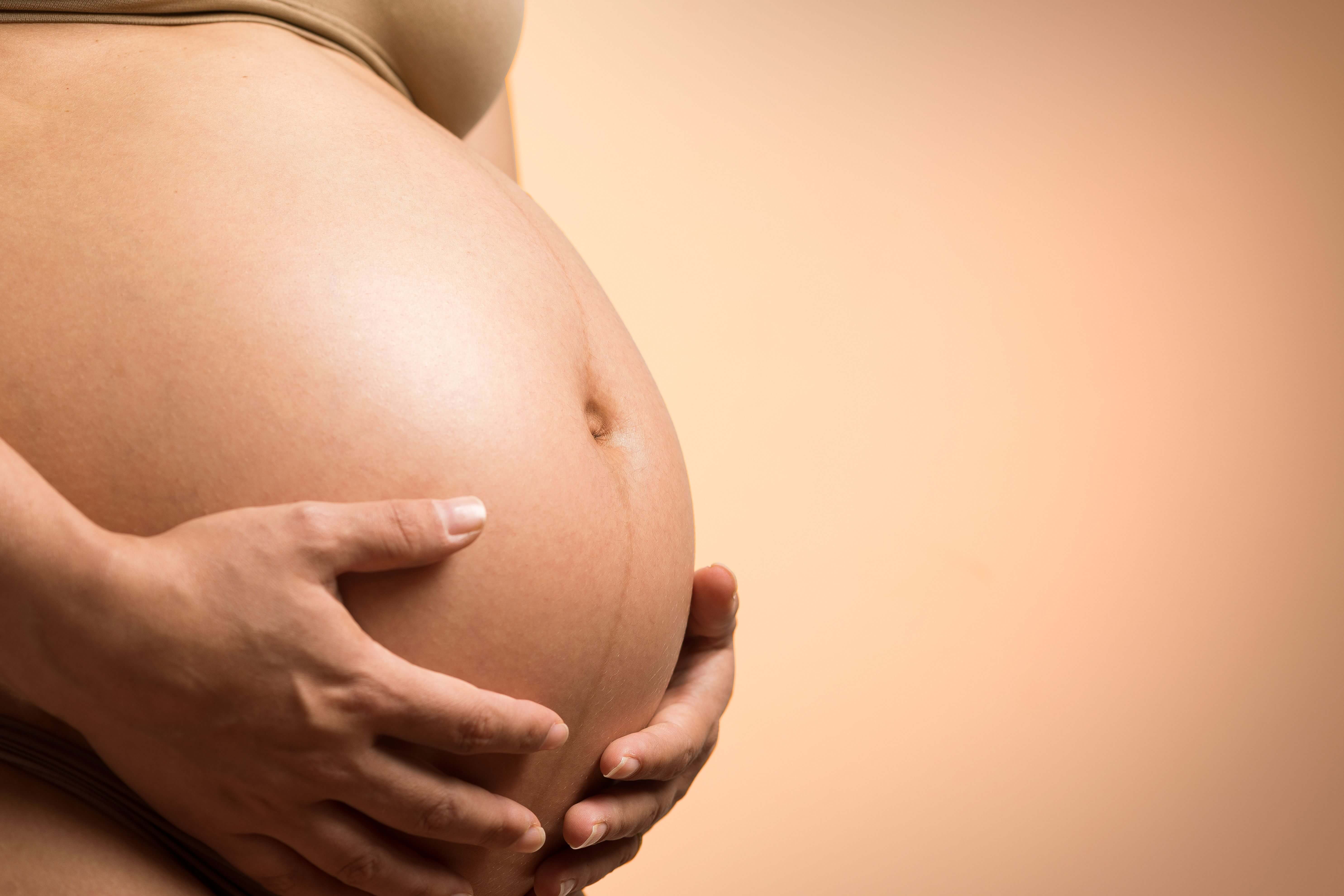 Pregnant client lying on her side supported by cushions during a pregnancy massage